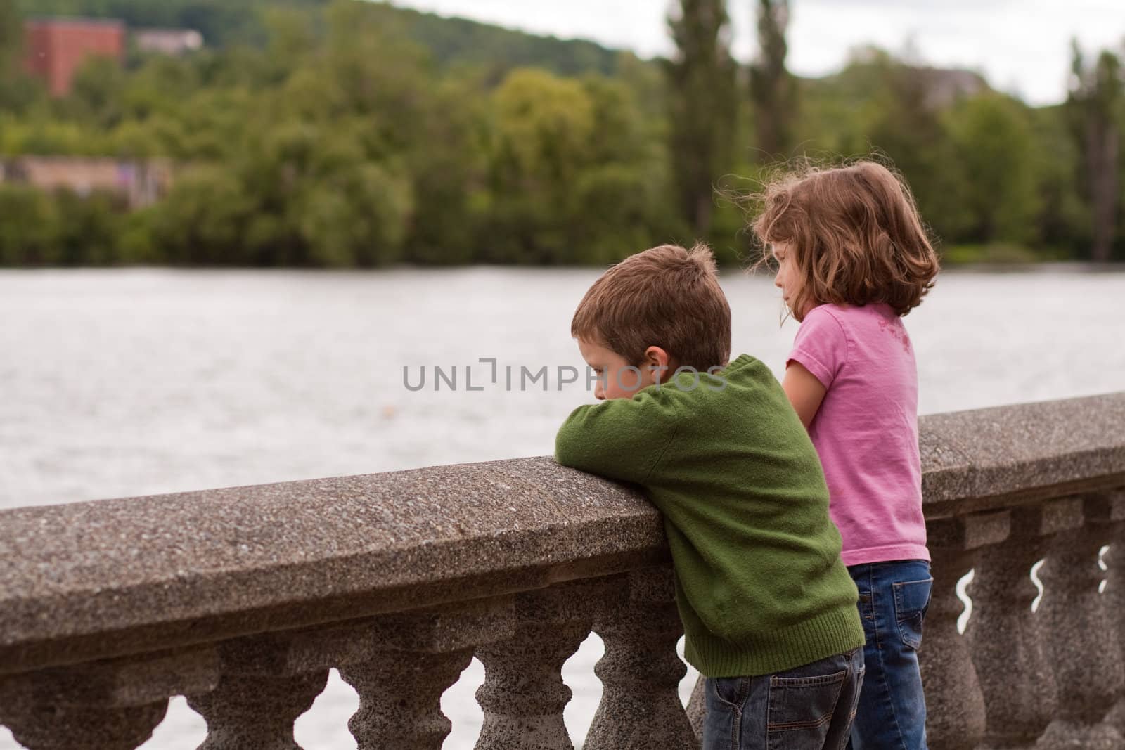 Cute little brother and sister looking at the river