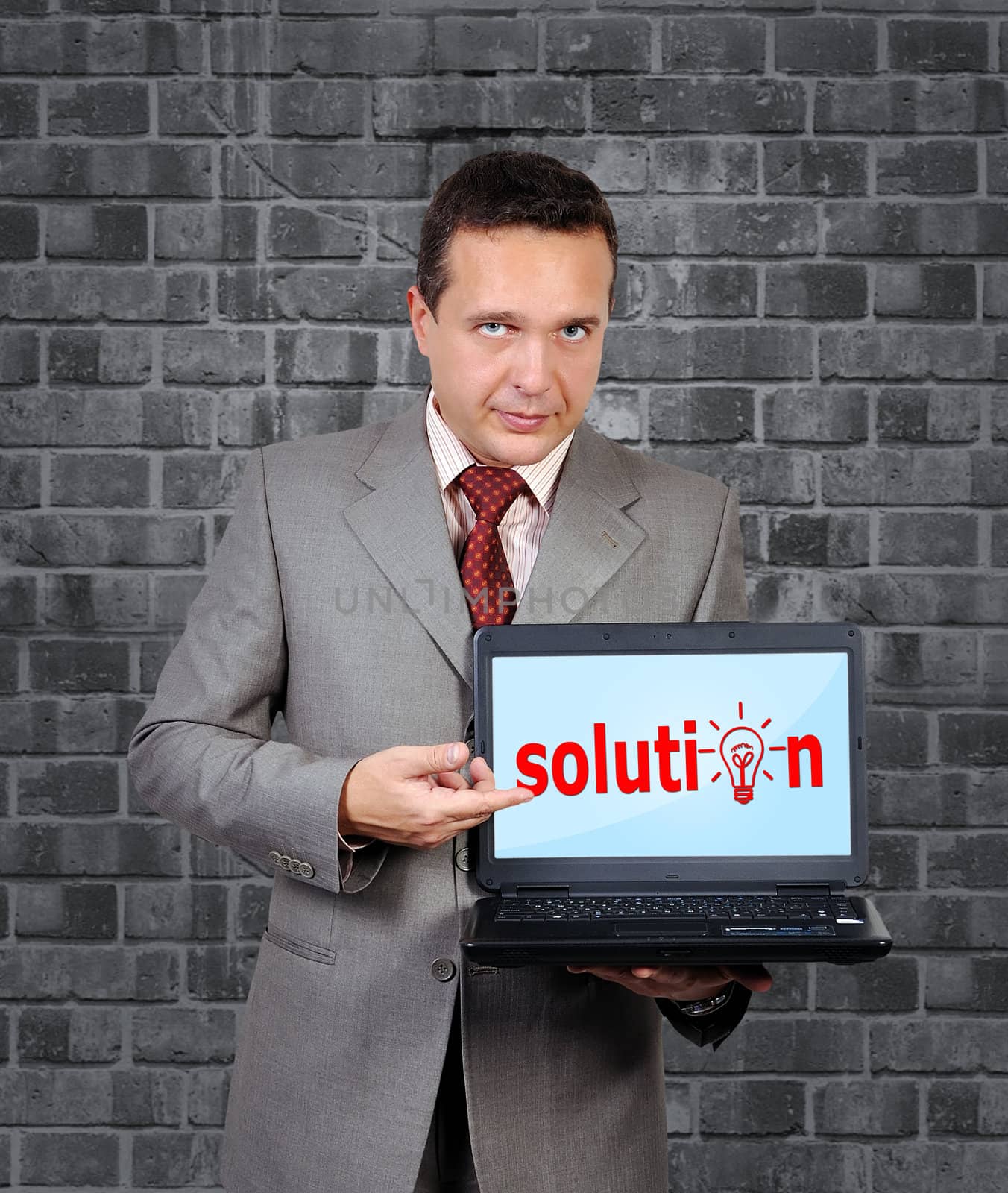 businessman with a laptop in hand points to solution symbol