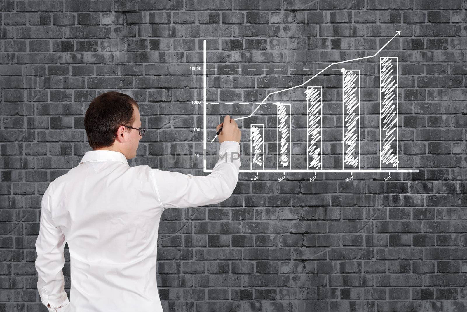 businessman drawing business chart on brick wall