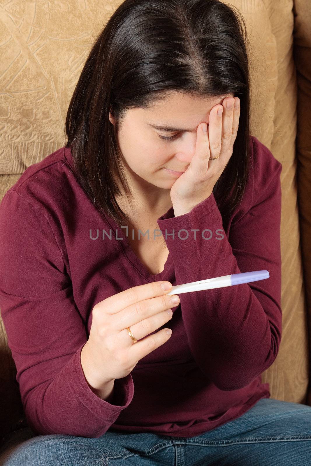 Woman holding a pregnancy test by Talanis