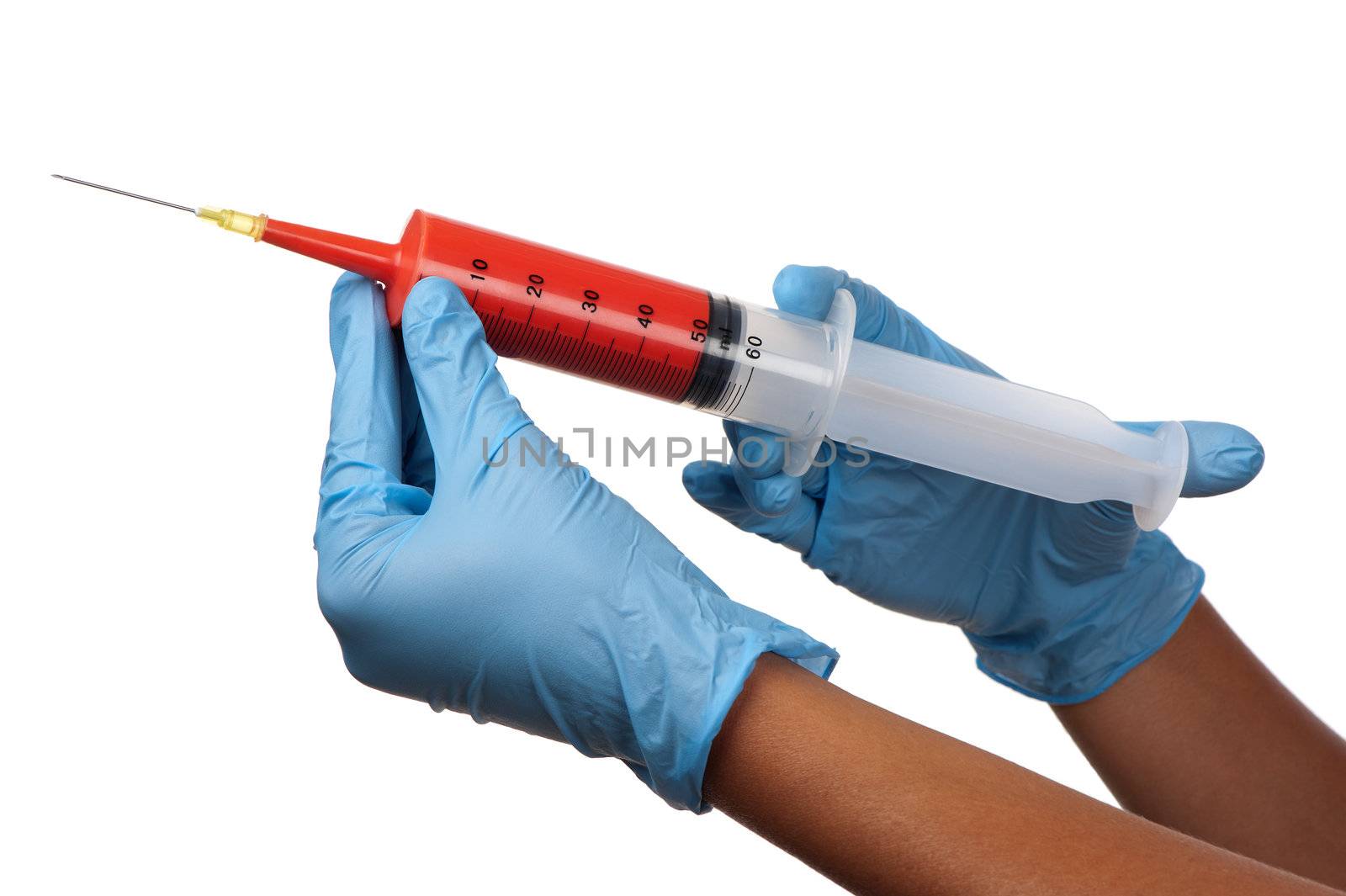 Two gloved hands hold a large injection syringe filled with a red substance.