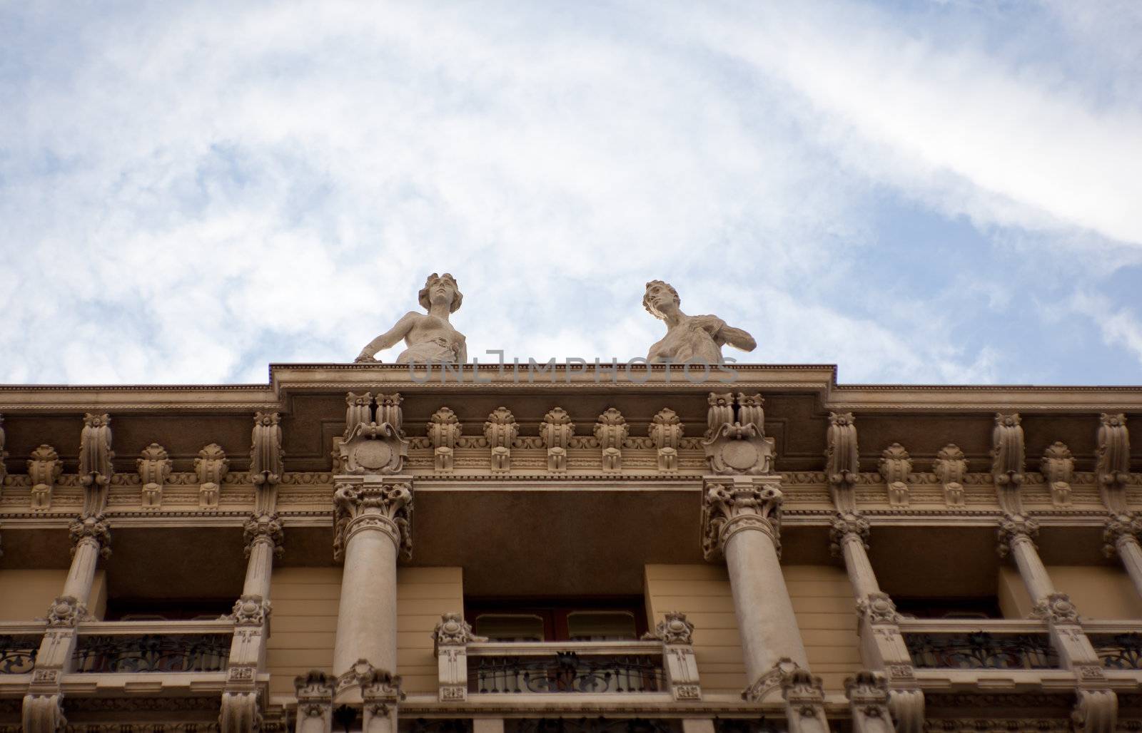 Two statues on building in Trieste, Italy