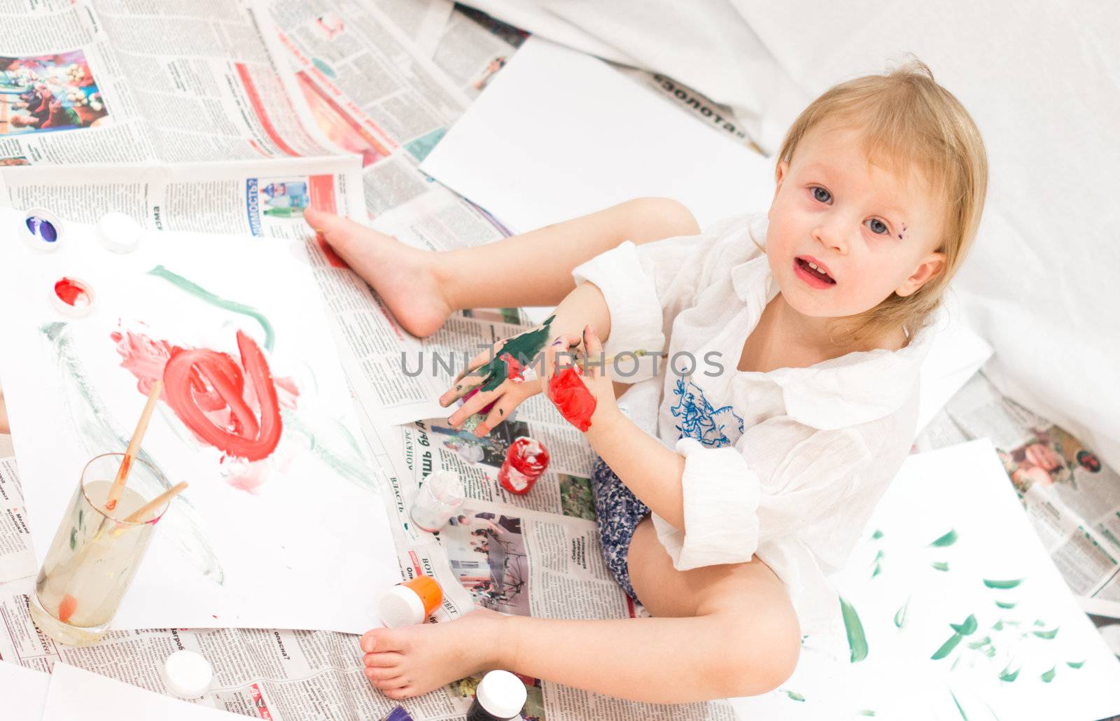 cheerful child draws pictures on newspapers by natochka