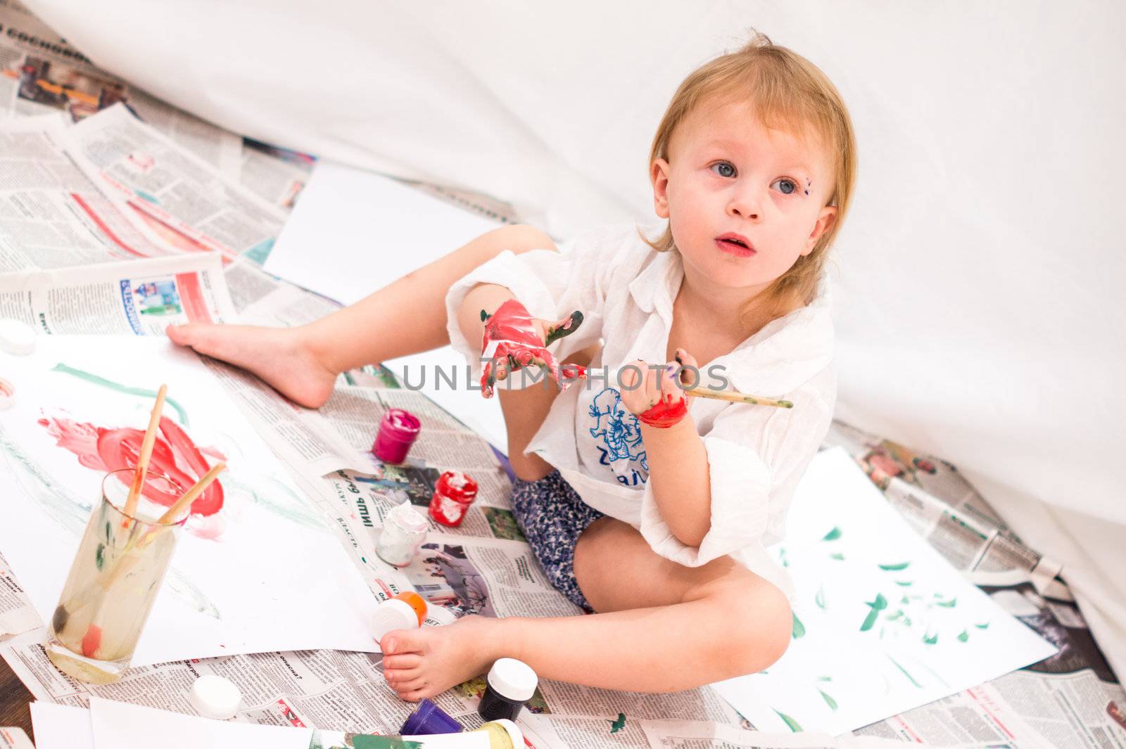 cheerful child draws pictures on newspapers by natochka