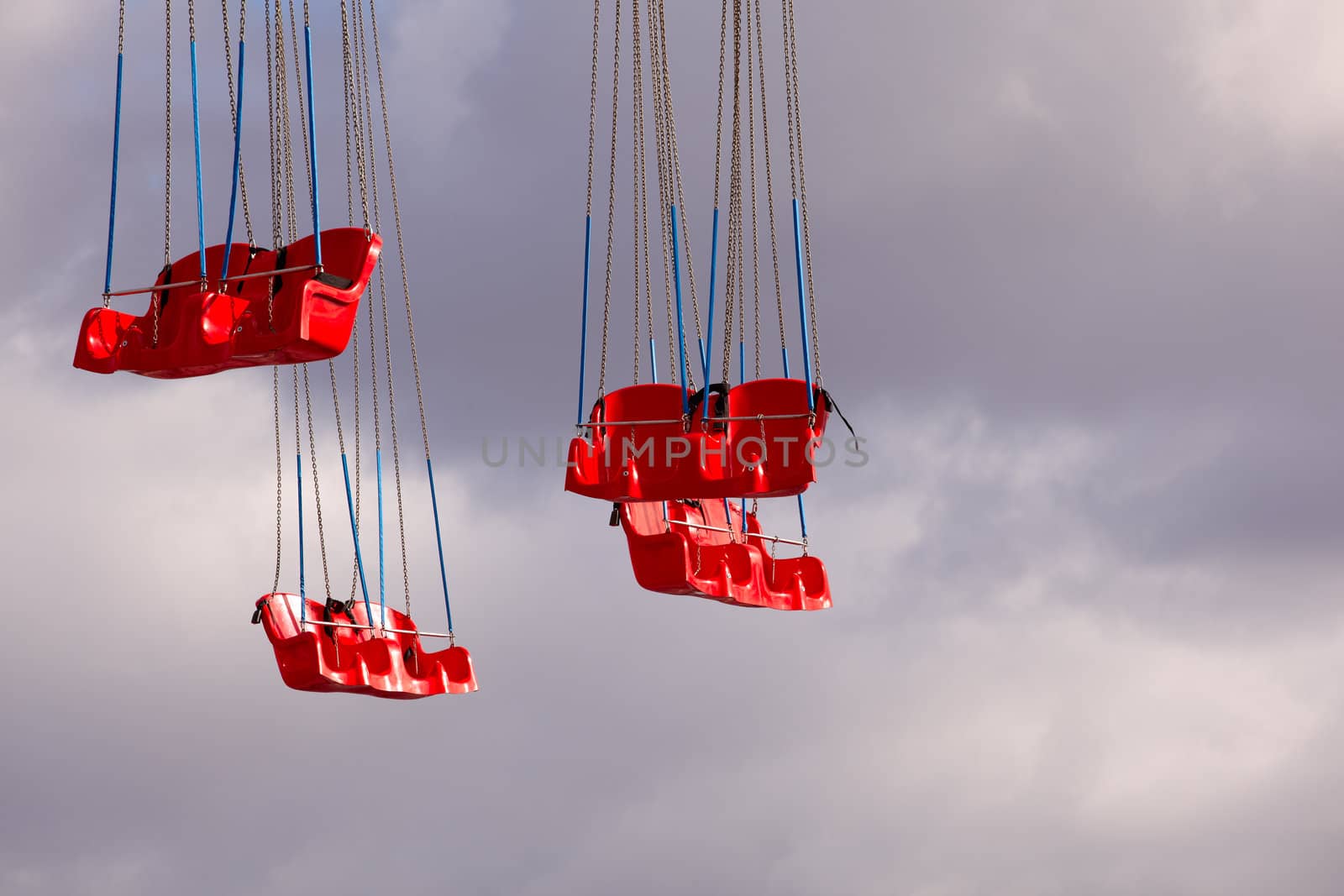 Red Carousel seats on cloudy sky