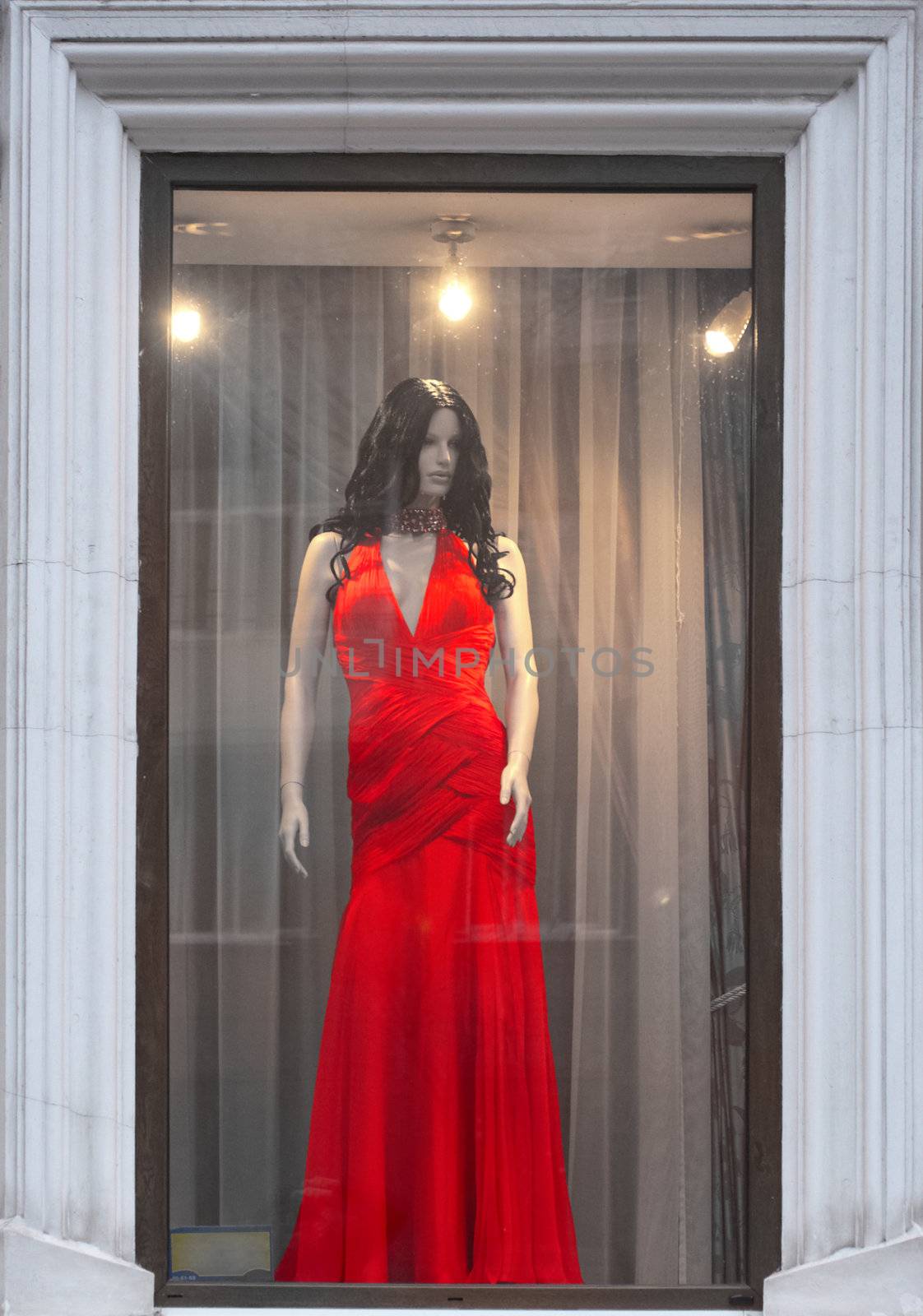 Female mannequin in a red dress in a shop window