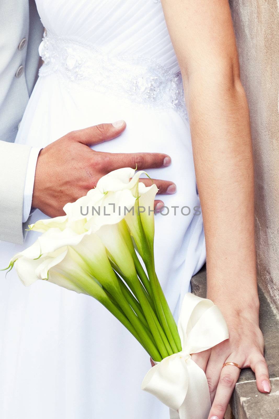 the bride and groom with a bouquet of flowers by jannyjus