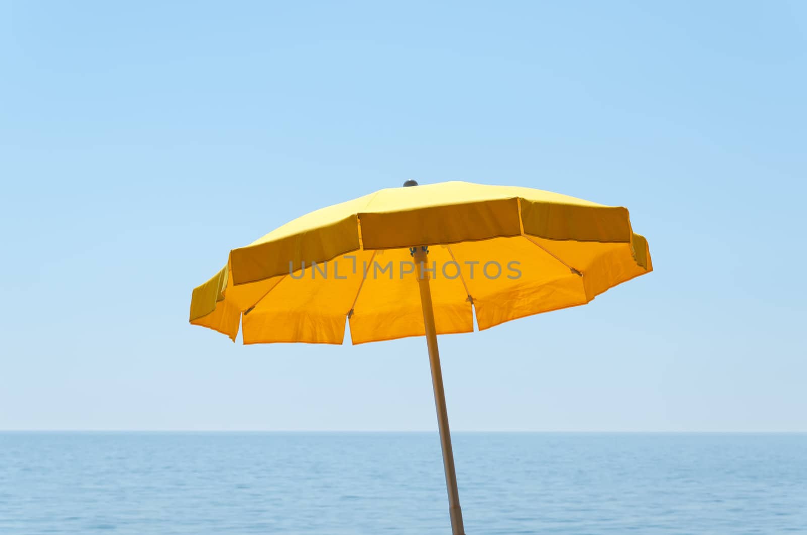 yellow umbrella over sea under blue sky by mycola
