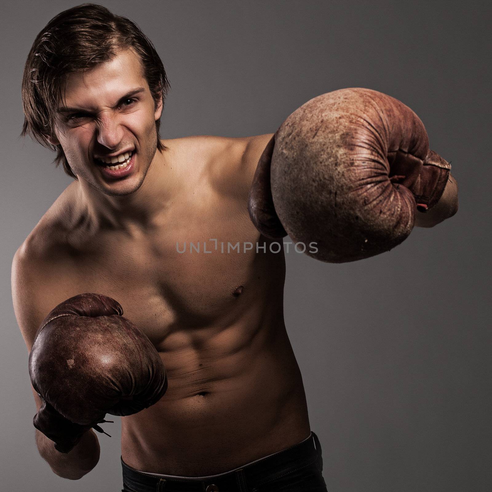 Agressive guy in a boxing gloves ready for a fight