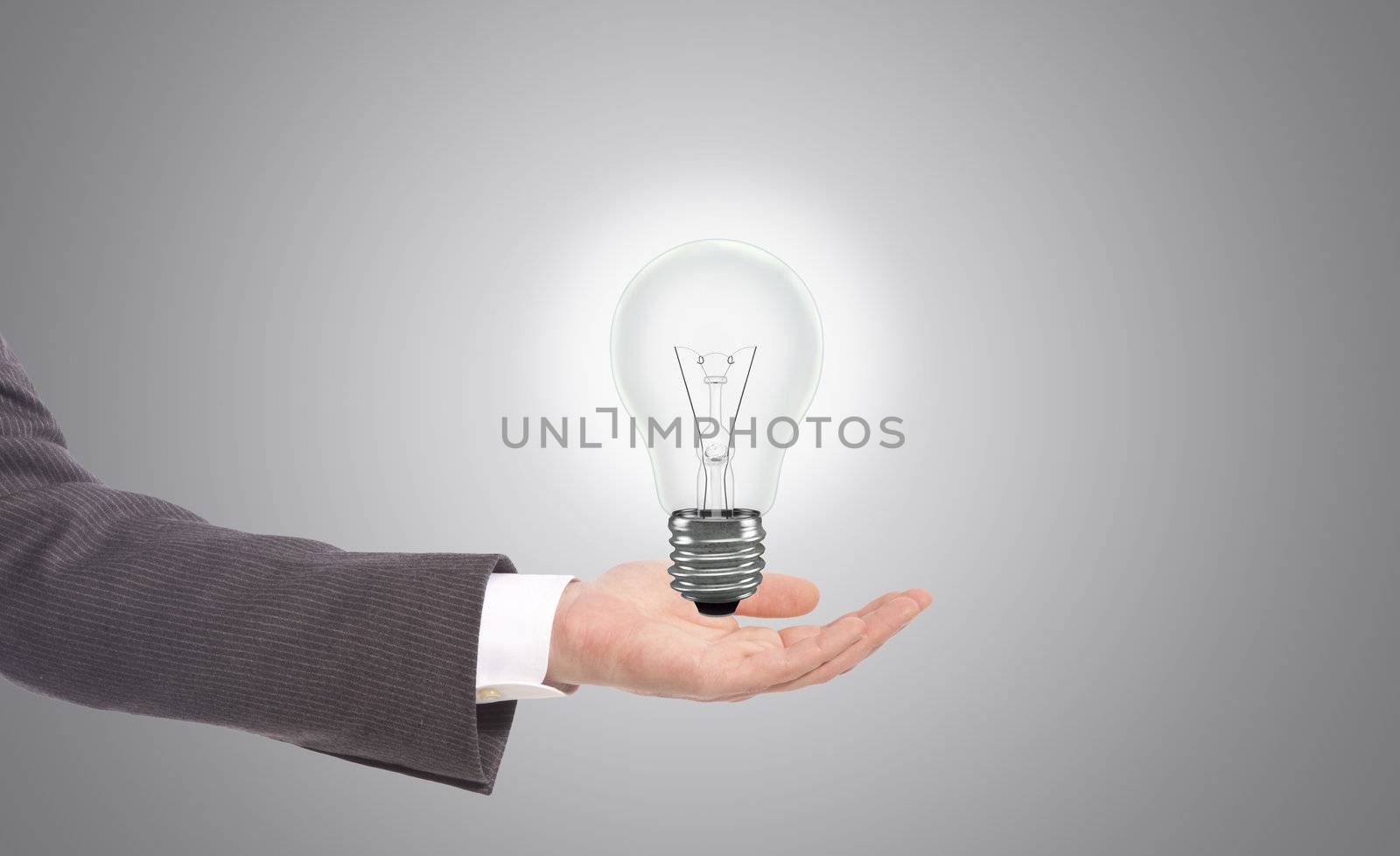 business man with light bulb in hand, grey background