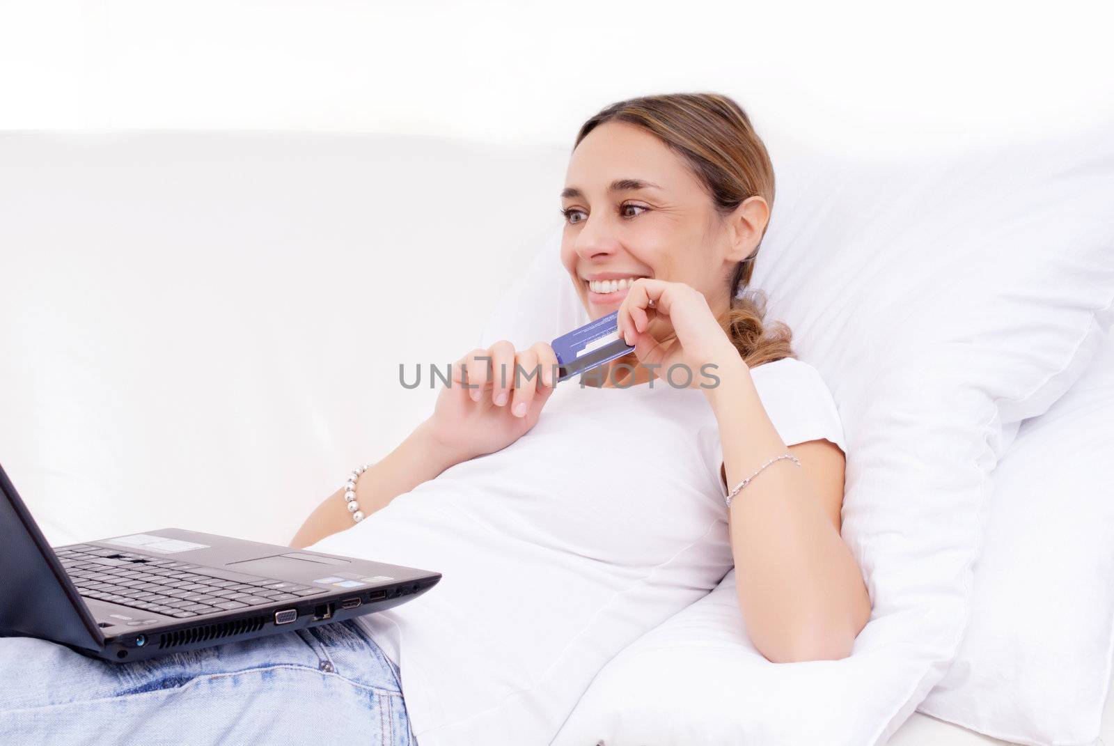 young attractive woman doing online shopping on sofa