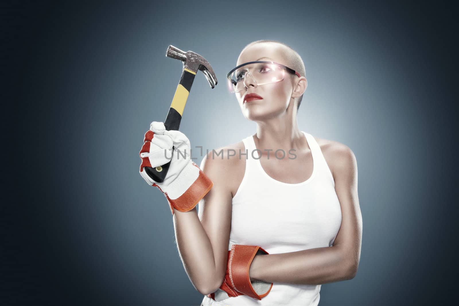 portrait of young beautiful  woman with hammer  on blue back