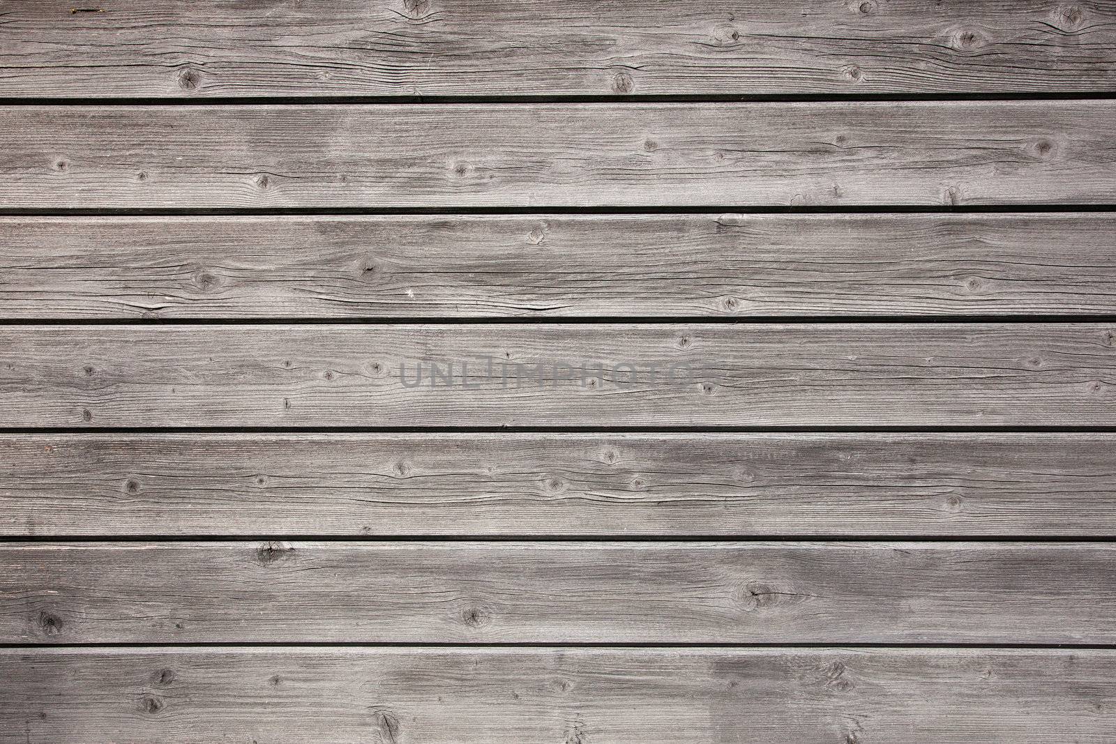 weathered grey boards of fencing by ahavelaar