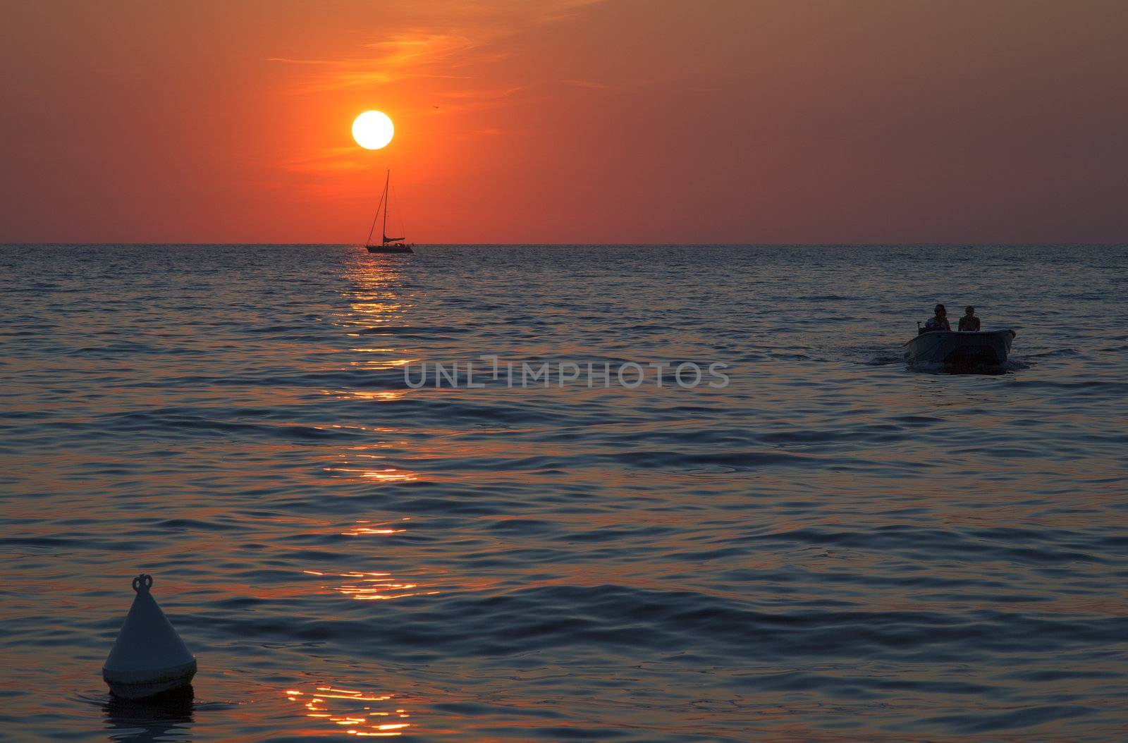 Sunset at sea with a sailboat in Trieste