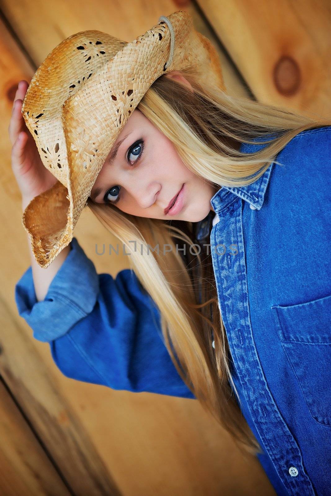 Attractive Blond Model Peers Out From Under Her Tattered Cowboy Hat