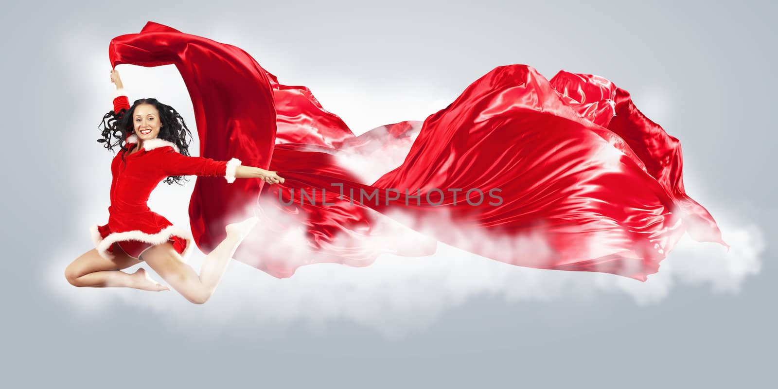 Happy smiling woman in red xmas costume jumping high