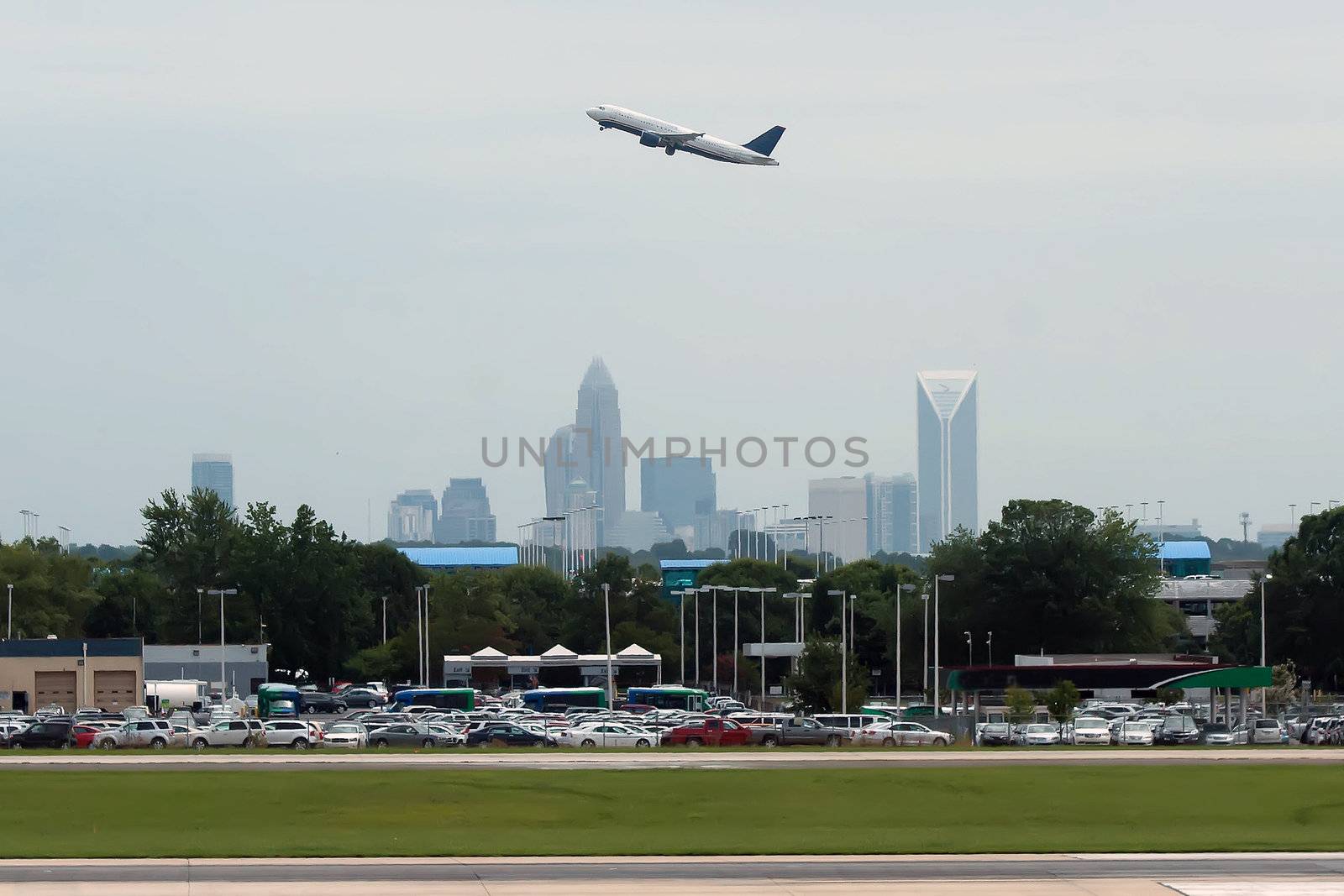 Commercial jet in the air with city skyline in the background.