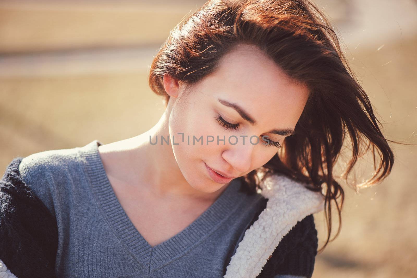 Spring outdoor closeup portrait of young thoughtful woman.