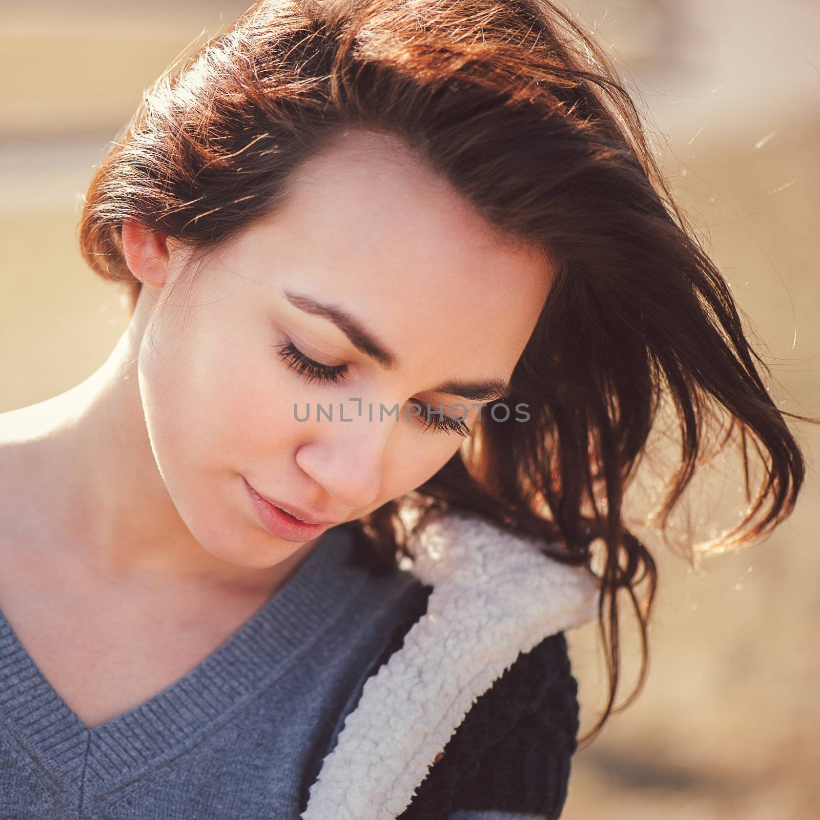 Spring outdoor closeup portrait of young thoughtful woman.