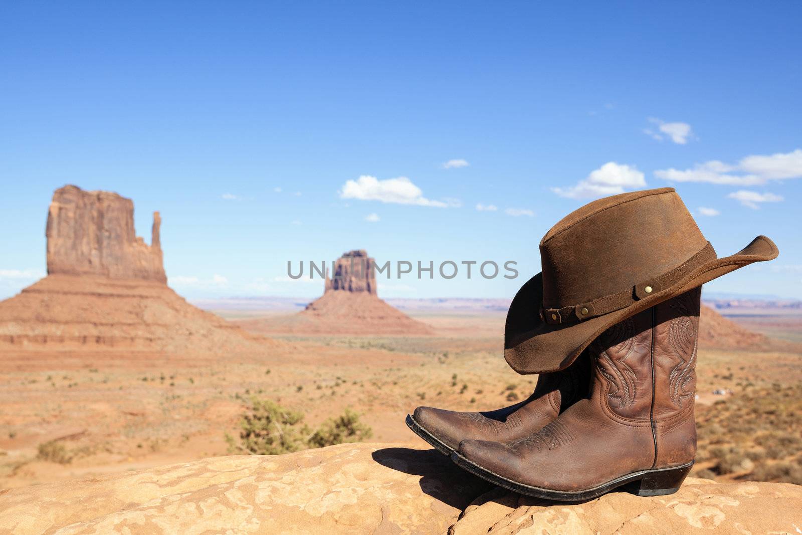 cowboy boots and hat in front of Monument Valley, USA, panoramic view
