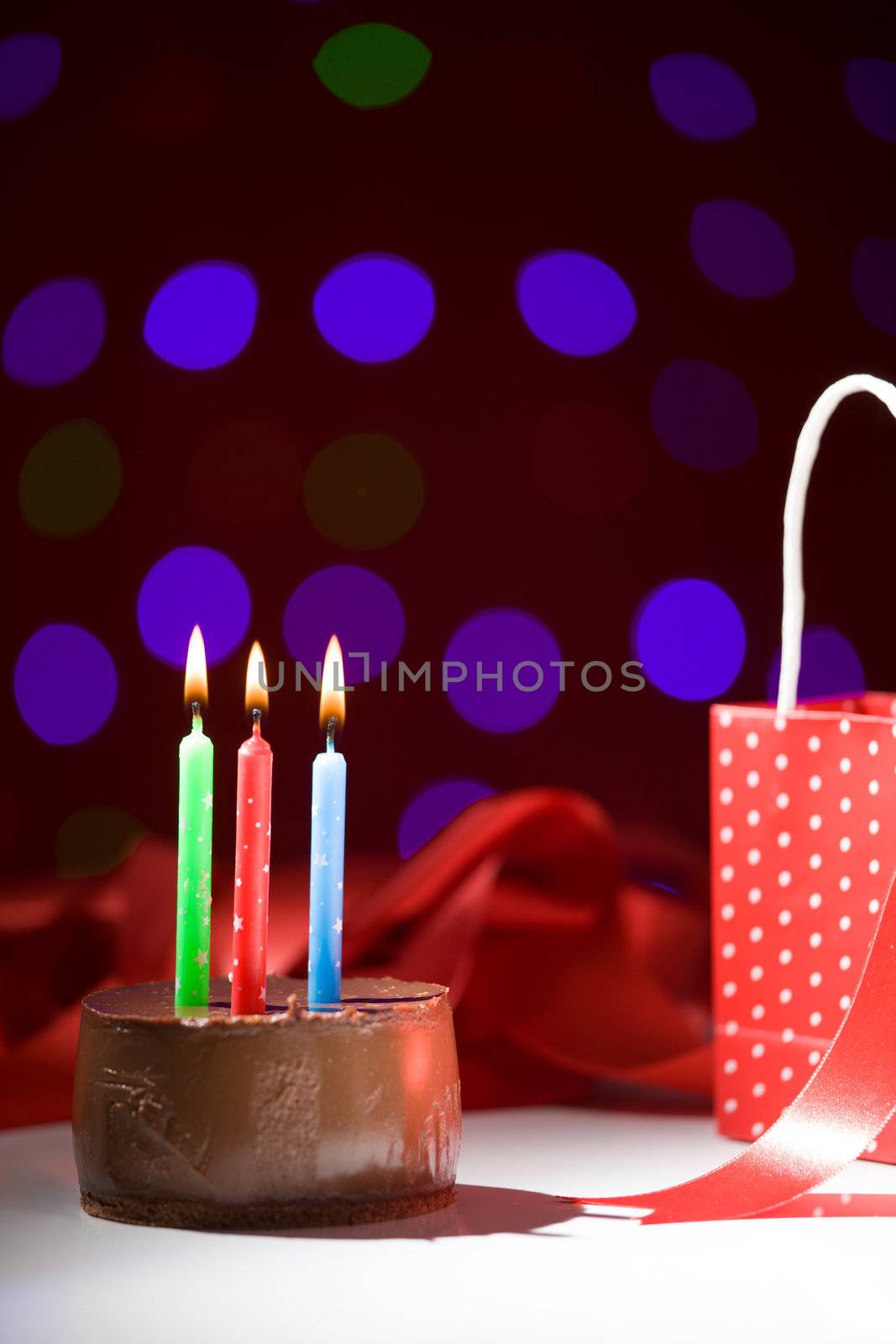 happy birthday cake shot on a red blurred background with candles