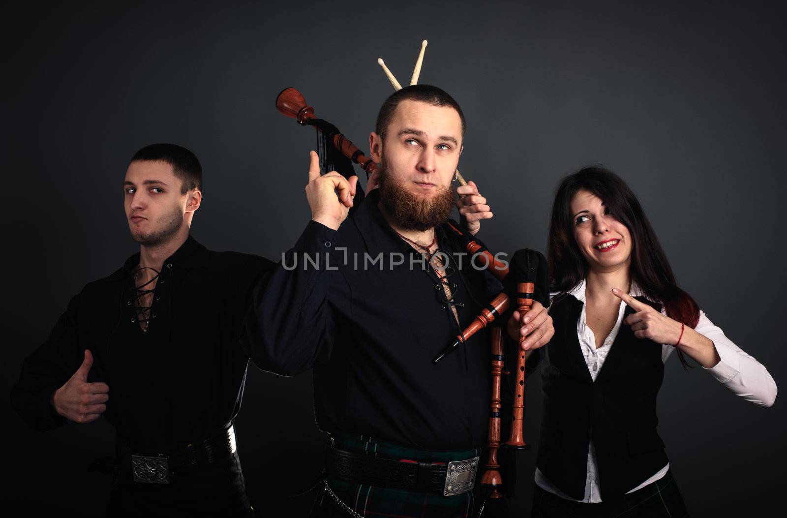 Musical band in scottish costumes with pipe and drums. Studio shot