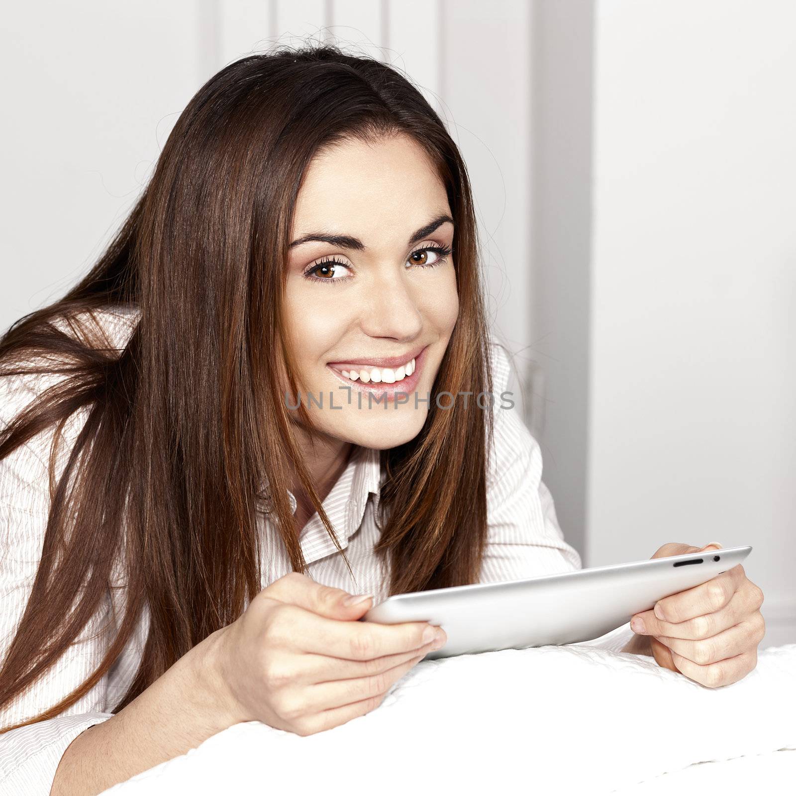 Beautiful smiling woman on sofa with tablet 