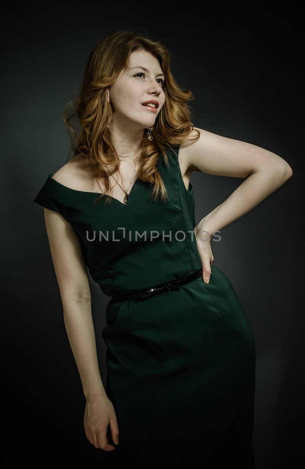 Beutiful young woman  with red hairs in green dress.