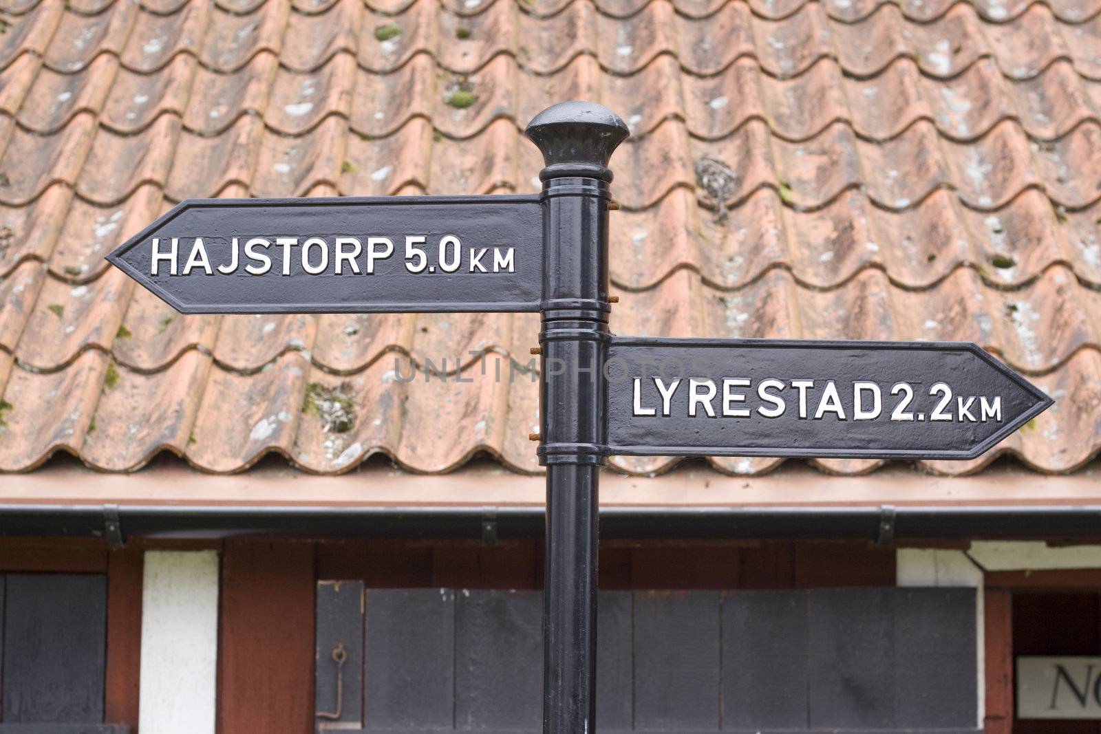 An old black cast iron sign shows direction next to Gota Canal, a canal that goes through the South of Sweden