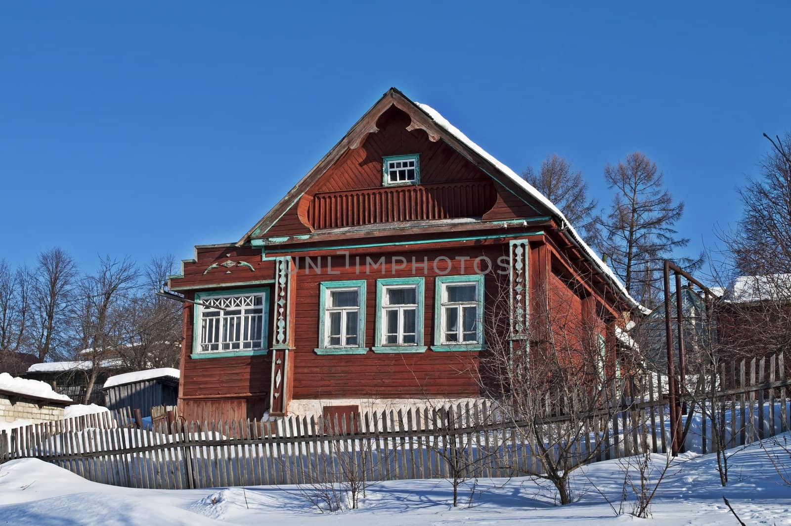 Old wooden house on a hillside, winter sunny day
