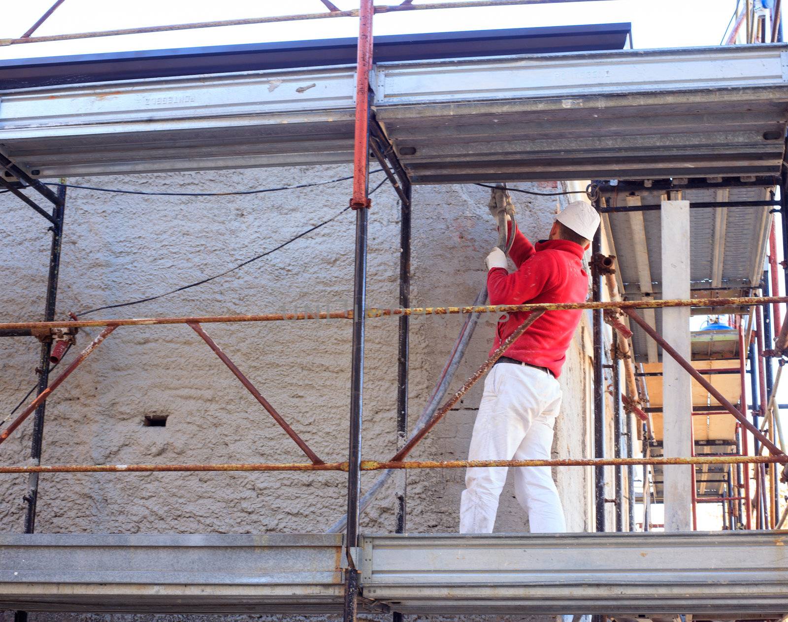 Bricklayer work with cement on scaffold
