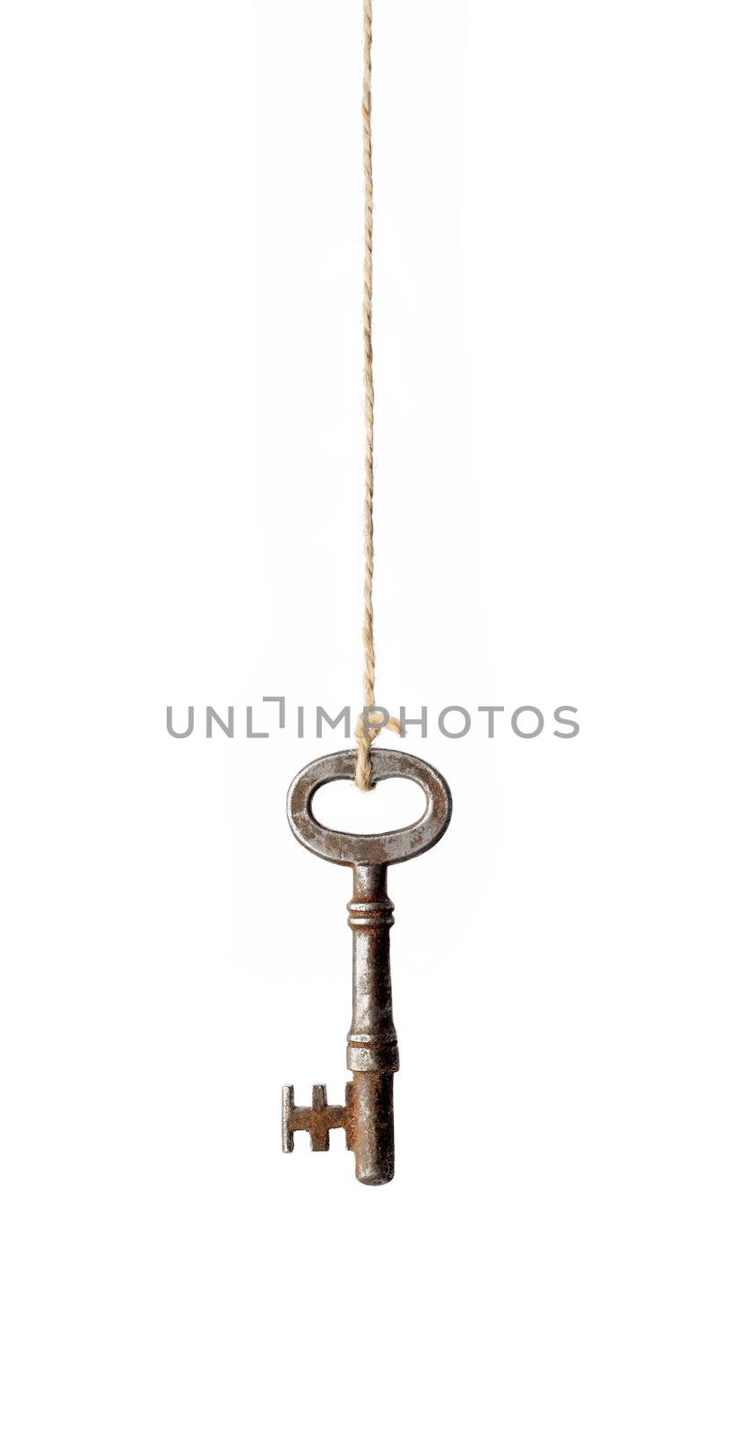 Old antique rusty key hanging from a string.