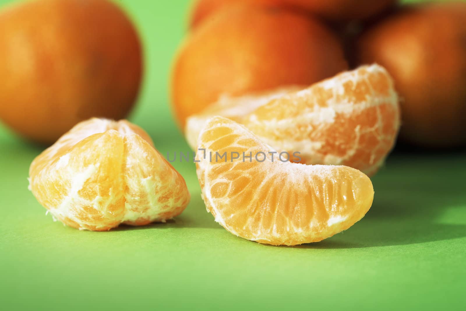Mandarin orange segments on green background.