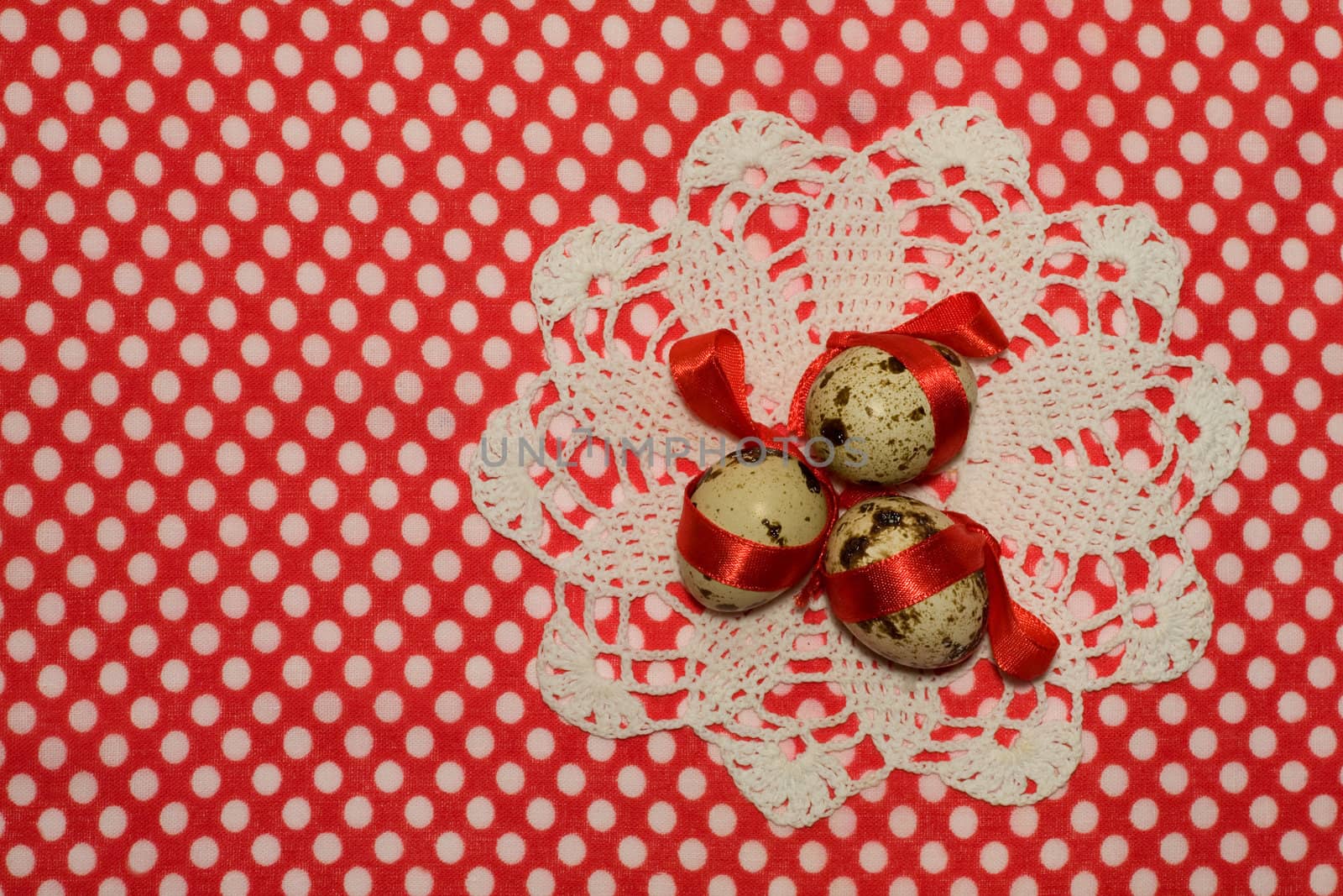 Easter eggs with red ribbon  in nest and  white napkin  on red