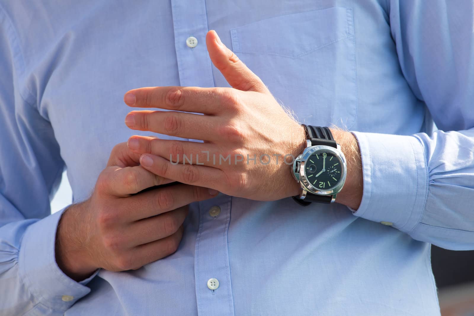 Hands of man in shirt holds a phone