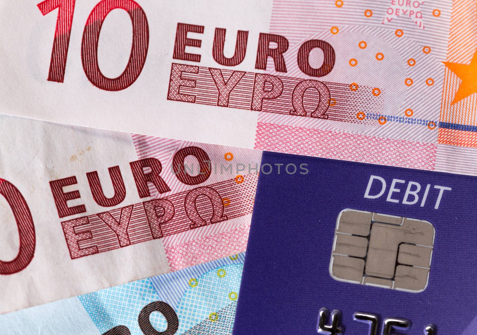 Debit word on plastic card on euro note suggesting debt problems in Europe