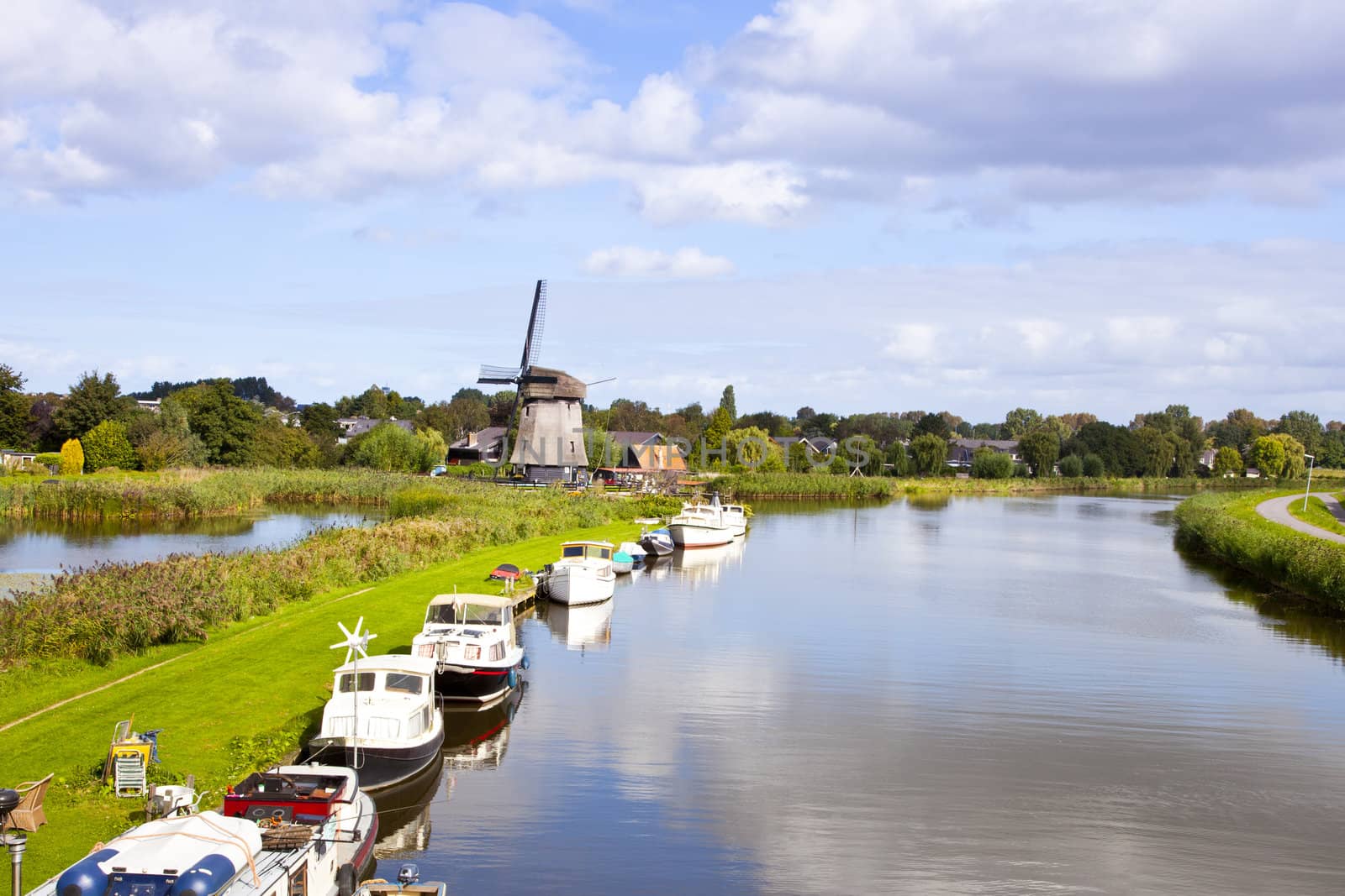 Dutch wind mill at river with little boats