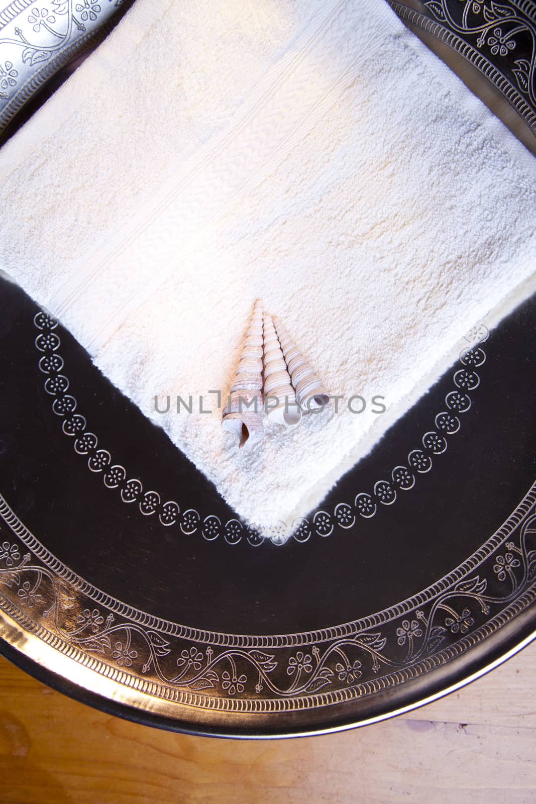 Luxury towel with shells in silver scale on wooden table