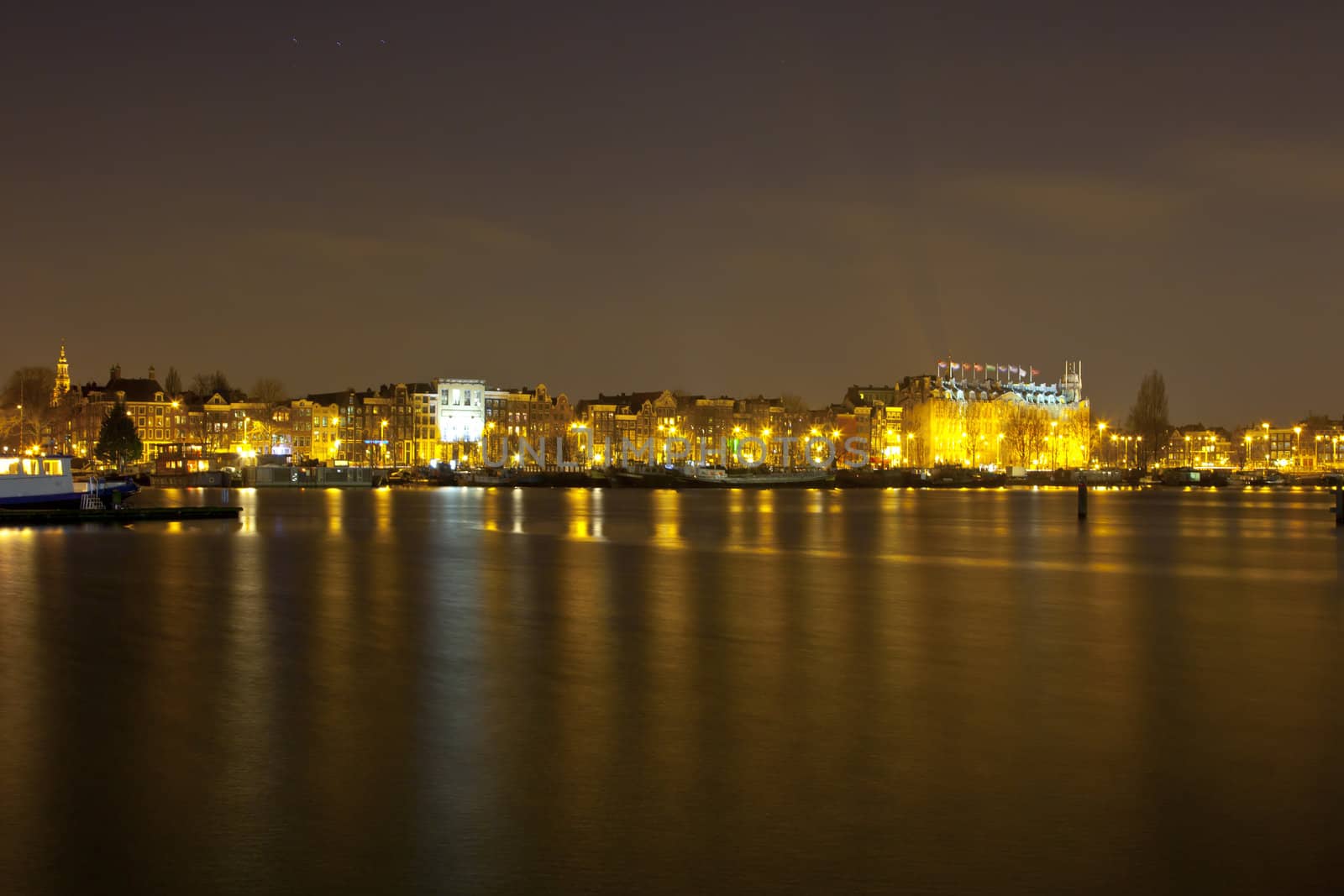 Amsterdam skyline at night with historic buildings and boats