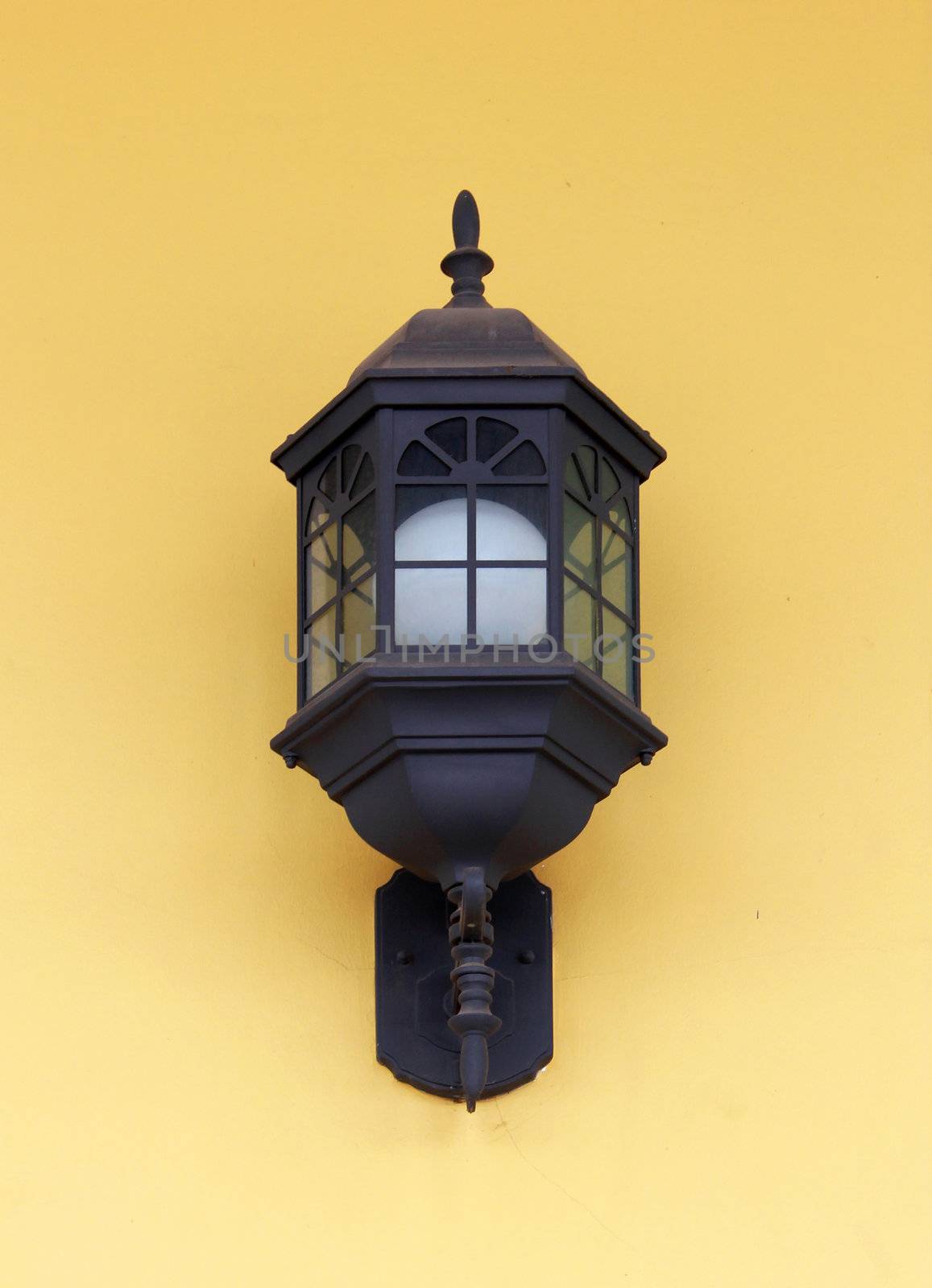 Vintage street lamp on yellow wall  by nuchylee