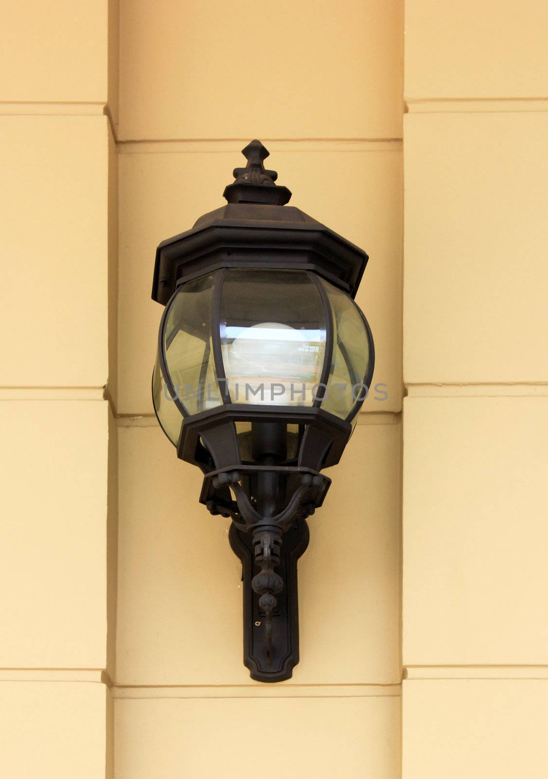 Vintage street lamp on yellow wall  by nuchylee