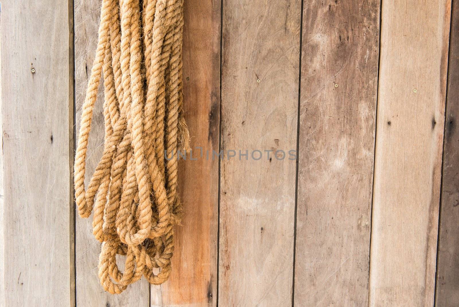 Large cow boy rope hanging with wooden background texture, taken outdoor