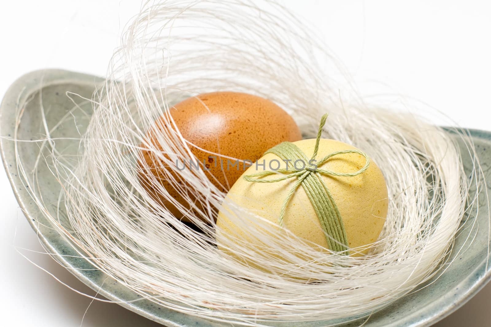 Easter eggs in a white nest on a plate