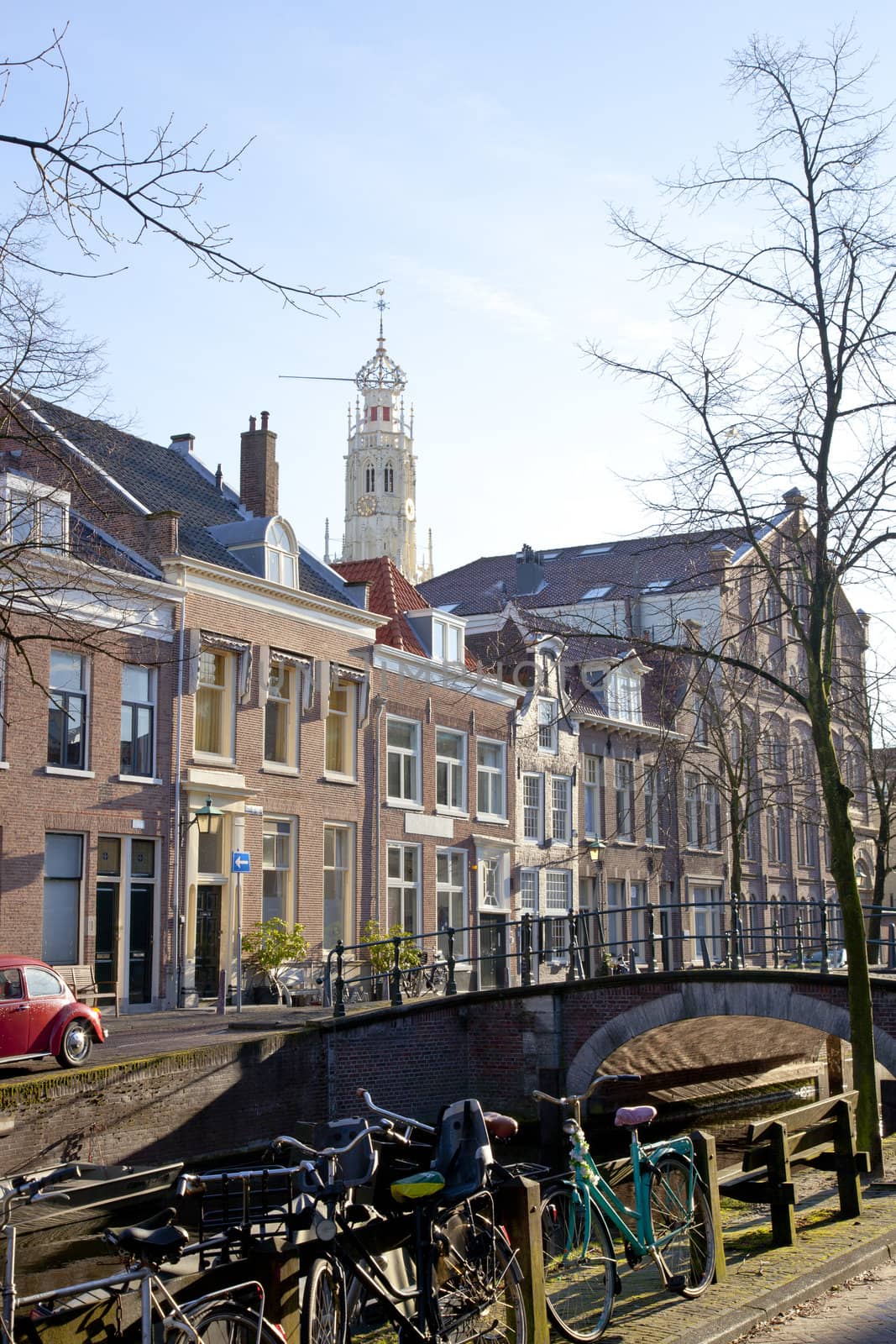 Dutch canal with old houses, church and bridge with blue sky