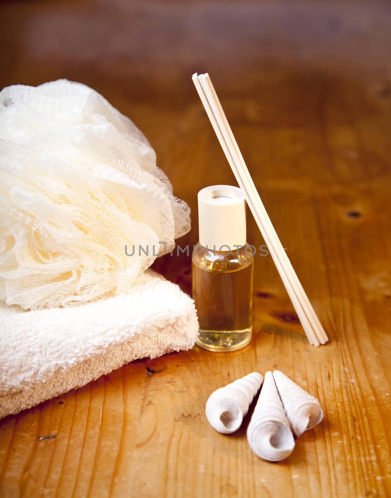 Luxury bath or shower set with towel, sponge, perfume and shells on wooden table