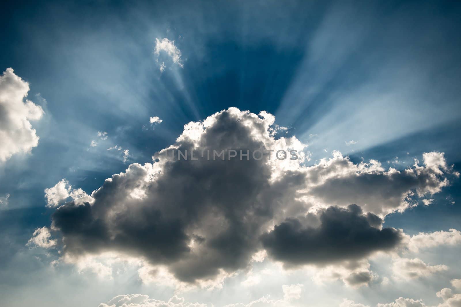 A storm grey cloud blocking the sun, giving the ray of light at the background