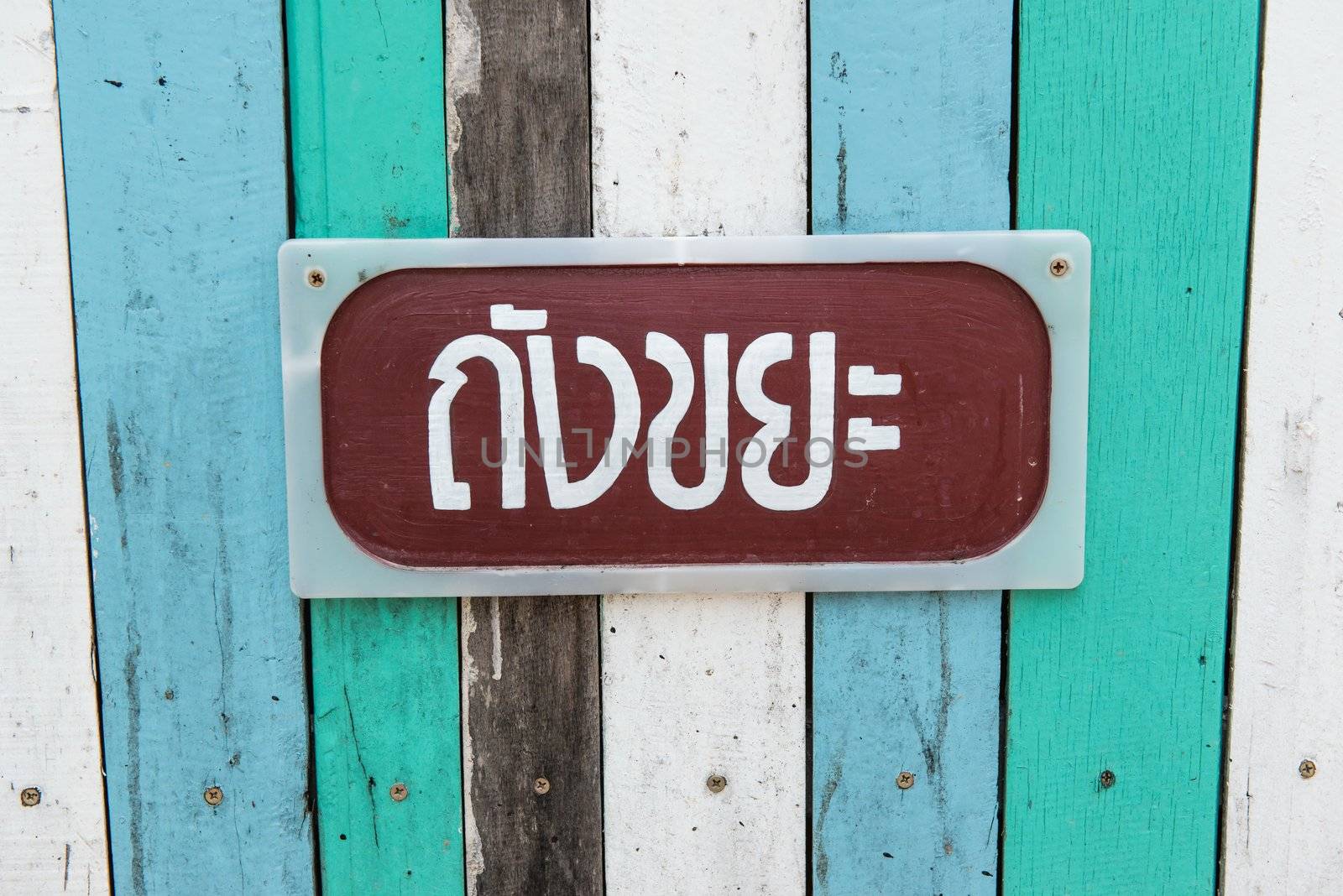 Blue, white, black contrasting old wooden texture background with metal sign, taken on a sunny day