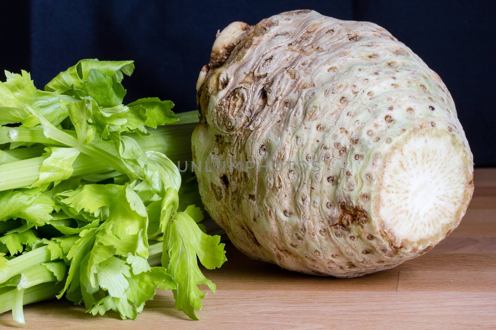 Fresh celery root with it's leafs on wooden table