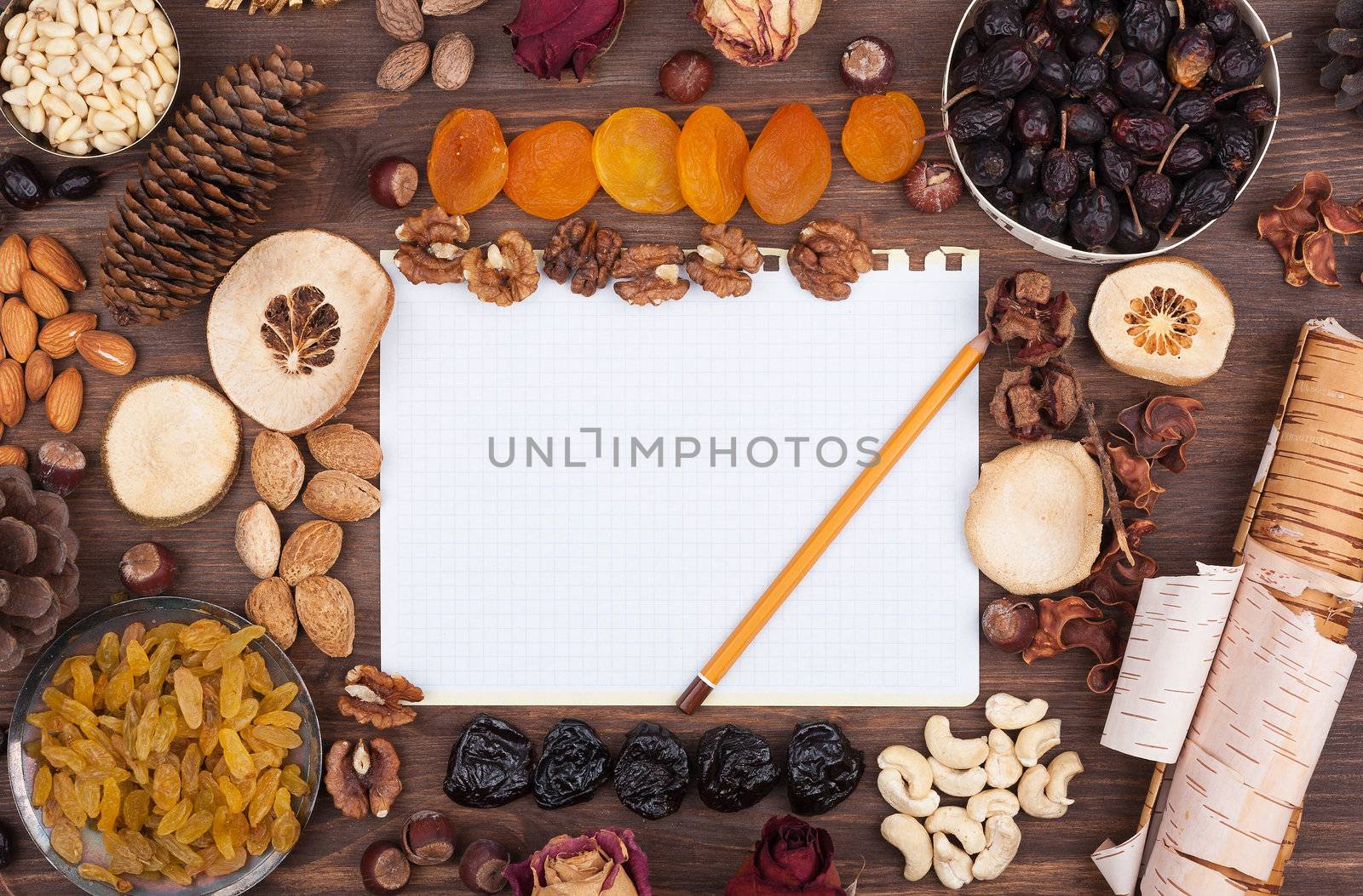 White sheet of paper with a pencil in an environment of nuts and fruits