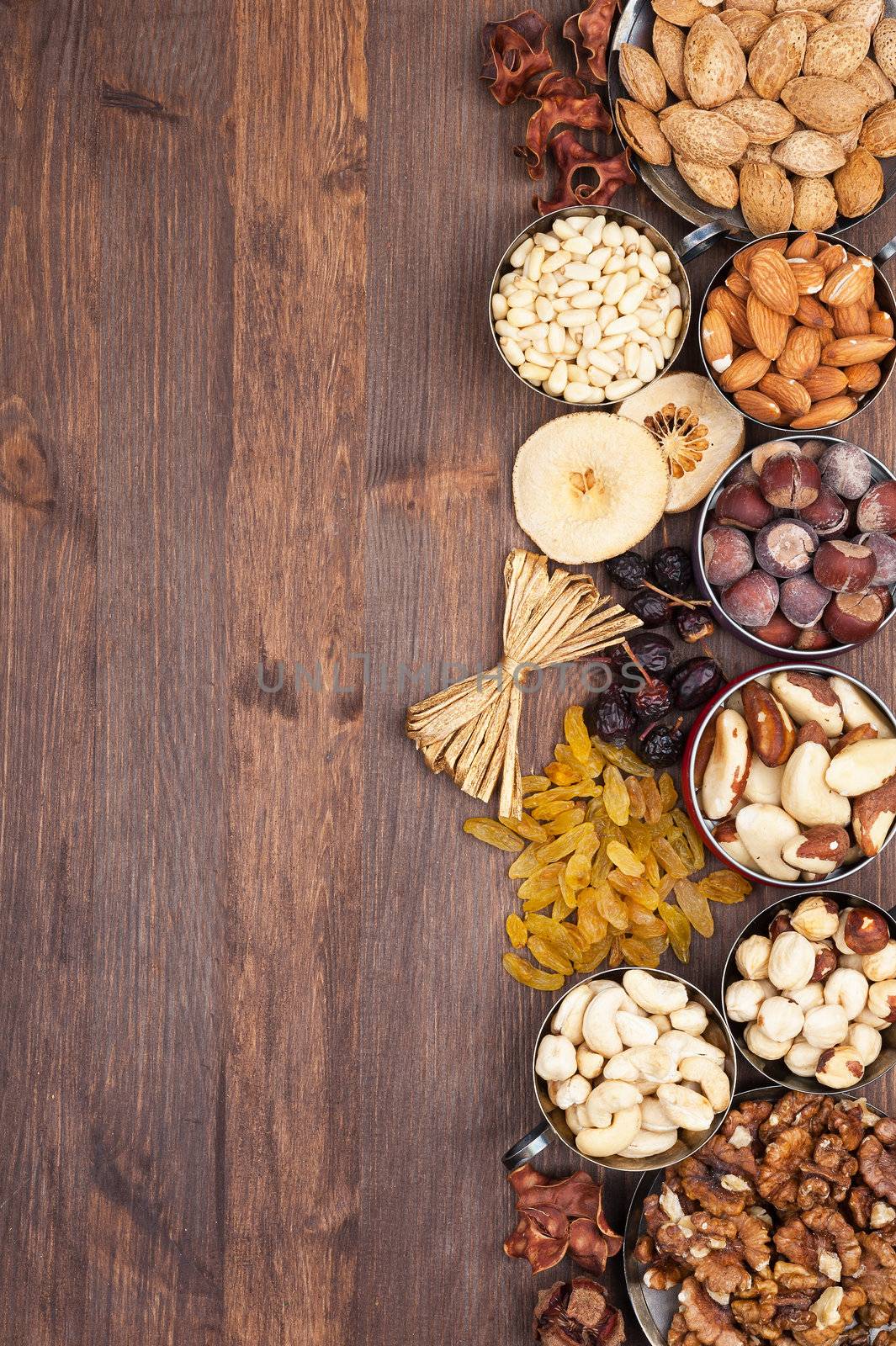 Frame of variety of fruits and nuts on a dark wooden surface